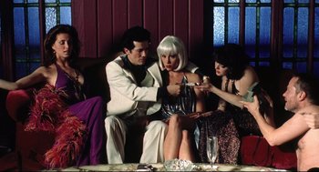 Movie still from “Summer of Sam” (1999), directed by Spike Lee – A group of people sitting around a table; Medium shot, Low angle