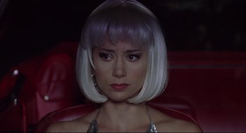 Movie still from “Summer of Sam” (1999), directed by Spike Lee – A woman with white hair sitting on a red chair; Close Up shot, Low angle