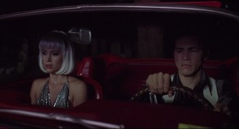 Movie still from “Summer of Sam” (1999), directed by Spike Lee – A man and a woman sitting in the back seat of a car; Medium shot, Low angle