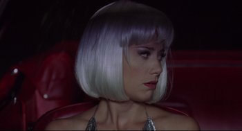 Movie still from “Summer of Sam” (1999), directed by Spike Lee – A woman with white hair sitting on a red couch; Close Up shot, Low angle