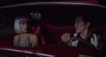 Movie still from “Summer of Sam” (1999), directed by Spike Lee – A man and a woman sitting in the back seat of a car; Medium shot, High angle