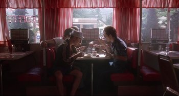 Movie still from “Summer of Sam” (1999), directed by Spike Lee – A group of people sitting at a table in a restaurant; Wide shot, Low angle