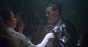 Movie still from “Summer of Sam” (1999), directed by Spike Lee – A man in a black leather jacket is holding a microphone; Close Up shot, Over the shoulder angle