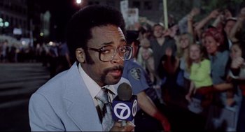 Movie still from “Summer of Sam” (1999), directed by Spike Lee – A man in a blue suit is holding a microphone; Close Up shot, Low angle