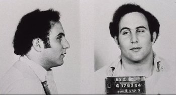 Movie still from “Summer of Sam” (1999), directed by Spike Lee – A black - and - white photo of a man in a police mugshot; Close Up shot, Low angle
