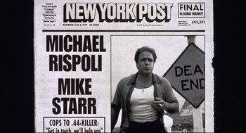 Movie still from “Summer of Sam” (1999), directed by Spike Lee – A man standing in front of a new york post newspaper; Medium shot, Low angle