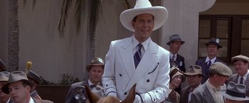 Movie still from “Sunset” (1988), directed by Blake Edwards – A man in a white suit and a white cowboy hat; Medium shot, Over the shoulder angle