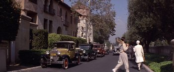 Movie still from “Sunset” (1988), directed by Blake Edwards – A row of antique cars parked along a street; Extreme Wide shot, Low angle