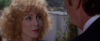 Movie still from “Sunset” (1988), directed by Blake Edwards – A person with curly red hair; Close Up shot, Over the shoulder angle