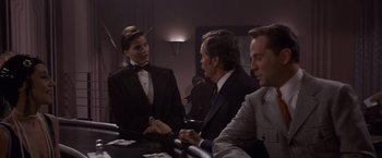 Movie still from “Sunset” (1988), directed by Blake Edwards – A group of people sitting at a table with cards; Medium shot, Over the shoulder angle