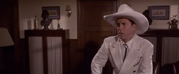 Movie still from “Sunset” (1988), directed by Blake Edwards – A man wearing a white suit and a white cowboy hat; Medium shot, Low angle