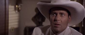 Movie still from “Sunset” (1988), directed by Blake Edwards – A man wearing a white cowboy hat looking up; Close Up shot, Over the shoulder angle