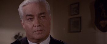 Movie still from “Sunset” (1988), directed by Blake Edwards – An older man in a military uniform looking at the camera; Close Up shot, Over the shoulder angle