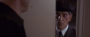 Movie still from “Sunset” (1988), directed by Blake Edwards – A person wearing a suit and tie; Close Up shot, Over the shoulder angle
