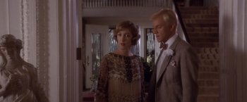 Movie still from “Sunset” (1988), directed by Blake Edwards – A man and a woman standing next to each other in a room; Medium shot, Over the shoulder angle
