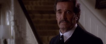 Movie still from “Sunset” (1988), directed by Blake Edwards – An older man in a black suit and white tie; Close Up shot, High angle