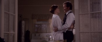 Movie still from “Sunset” (1988), directed by Blake Edwards – A man and a woman standing next to each other in a kitchen; Medium shot, Low angle