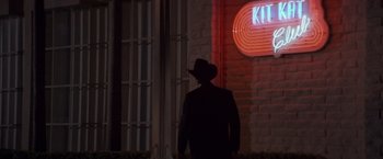 Movie still from “Sunset” (1988), directed by Blake Edwards – A man wearing a cowboy hat standing in front of a building; Wide shot, Low angle