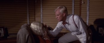 Movie still from “Sunset” (1988), directed by Blake Edwards – An older man and a younger woman in a room with blinds; Close Up shot, Over the shoulder angle