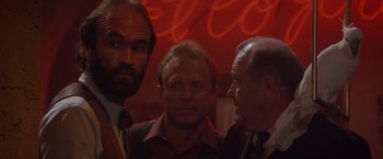 Movie still from “Sunset” (1988), directed by Blake Edwards – A group of men standing next to each other in front of a neon sign; Close Up shot, Over the shoulder angle