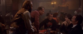 Movie still from “Sunset” (1988), directed by Blake Edwards – A group of men sitting at a table in a restaurant; Medium shot, Over the shoulder angle