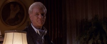 Movie still from “Sunset” (1988), directed by Blake Edwards – A person wearing a suit and tie; Close Up shot, Over the shoulder angle