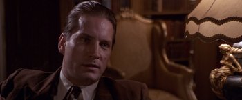 Movie still from “Sunset” (1988), directed by Blake Edwards – A person wearing a suit and tie; Close Up shot, Low angle