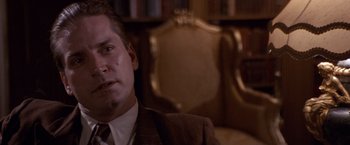 Movie still from “Sunset” (1988), directed by Blake Edwards – A person wearing a suit and tie; Close Up shot, Low angle