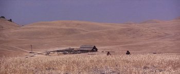 Movie still from “Sunset” (1988), directed by Blake Edwards – An old barn in the middle of a dry grass field; Extreme Wide shot, High angle