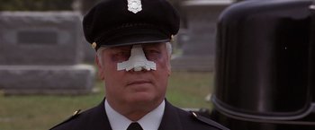 Movie still from “Sunset” (1988), directed by Blake Edwards – A police officer with bandages on his face; Close Up shot, Low angle