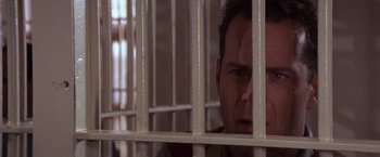 Movie still from “Sunset” (1988), directed by Blake Edwards – A person behind a fence; Close Up shot, Low angle