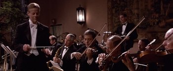 Movie still from “Sunset” (1988), directed by Blake Edwards – A group of men in suits playing musical instruments in a room; Wide shot, Low angle