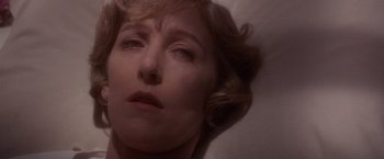 Movie still from “Sunset” (1988), directed by Blake Edwards – A woman's face in a dark room; Close Up shot, High angle
