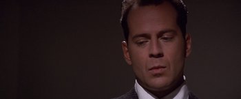 Movie still from “Sunset” (1988), directed by Blake Edwards – A person wearing a suit and tie; Close Up shot, Low angle