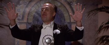 Movie still from “Sunset” (1988), directed by Blake Edwards – A man in a tuxedo waving at the crowd; Medium shot, Low angle