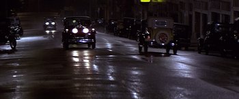 Movie still from “Sunset” (1988), directed by Blake Edwards – A couple of cars that are on the street; Wide shot, High angle