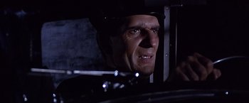 Movie still from “Sunset” (1988), directed by Blake Edwards – A man's face in the dark; Close Up shot, Low angle