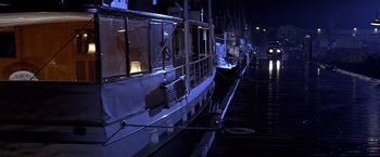 Movie still from “Sunset” (1988), directed by Blake Edwards – A boat docked at a pier at night; Extreme Wide shot, High angle