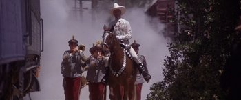 Movie still from “Sunset” (1988), directed by Blake Edwards – A man on a horse with a group of men in uniform; Wide shot, Low angle