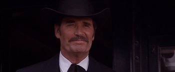 Movie still from “Sunset” (1988), directed by Blake Edwards – A person wearing a suit and a cowboy hat; Close Up shot, Low angle