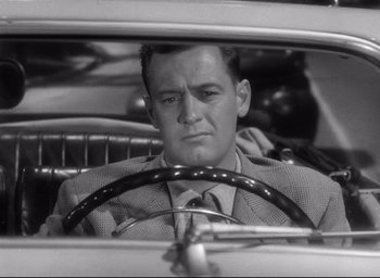 Movie still from “Sunset Blvd.” (1950), directed by Billy Wilder – A black and white photo of a man in a suit driving; Close Up shot, Low angle
