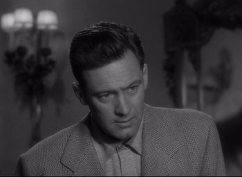 Movie still from “Sunset Blvd.” (1950), directed by Billy Wilder – A black and white photo of a man in a suit and tie; Close Up shot, Over the shoulder angle