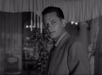 Movie still from “Sunset Blvd.” (1950), directed by Billy Wilder – A man in a suit and tie in front of a window; Close Up shot, Over the shoulder angle