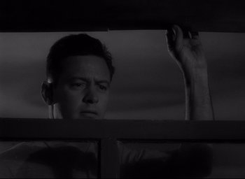 Movie still from “Sunset Blvd.” (1950), directed by Billy Wilder – A black and white photo of a man looking out of a window; Close Up shot, Low angle