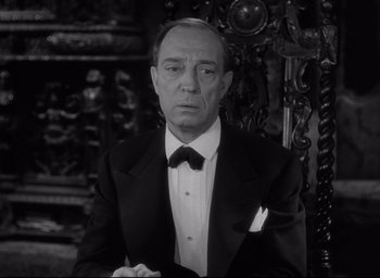 Movie still from “Sunset Blvd.” (1950), directed by Billy Wilder – An older man wearing a tuxedo in front of an ornate wall; Close Up shot, Low angle