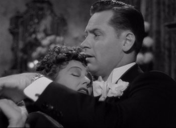 Movie still from “Sunset Blvd.” (1950), directed by Billy Wilder – A man and a woman embracing each other in a black and white photo; Close Up shot, Low angle