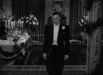 Movie still from “Sunset Blvd.” (1950), directed by Billy Wilder – A man in a tuxedo standing in front of a table; Medium shot, High angle