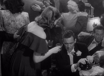 Movie still from “Sunset Blvd.” (1950), directed by Billy Wilder – A man and a woman in a room with other people; Medium shot, High angle