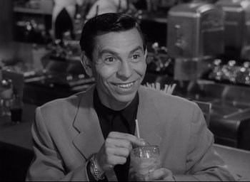 Movie still from “Sunset Blvd.” (1950), directed by Billy Wilder – A black and white photo of a man holding a drink; Close Up shot, High angle