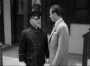 Movie still from “Sunset Blvd.” (1950), directed by Billy Wilder – A man in a uniform and a man in a suit talking to each other; Medium shot, Low angle